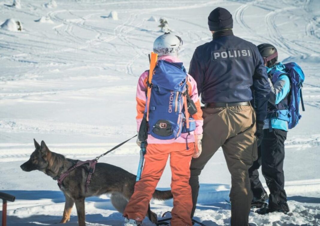 Kaksi siviiliä, koira ja poliisi